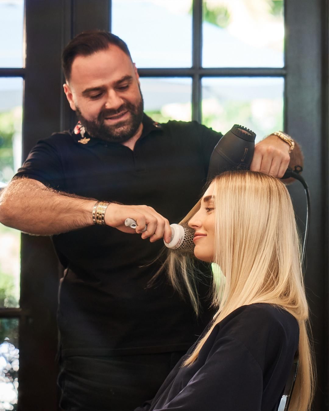 Male Stylist drying women hair in-salon at Brazilian Court 